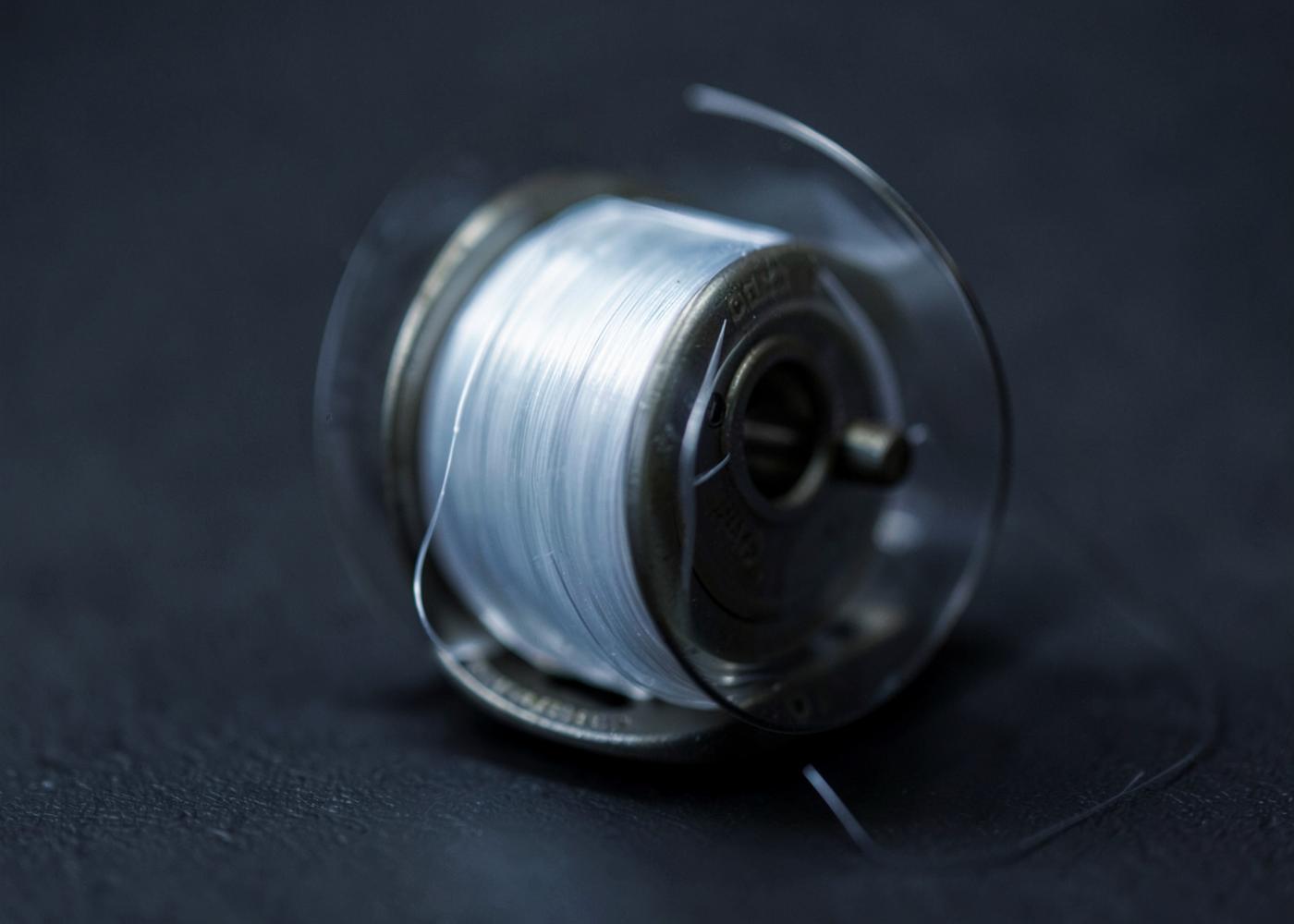 Macro detail of fine fishing line on a small spinning reel spool